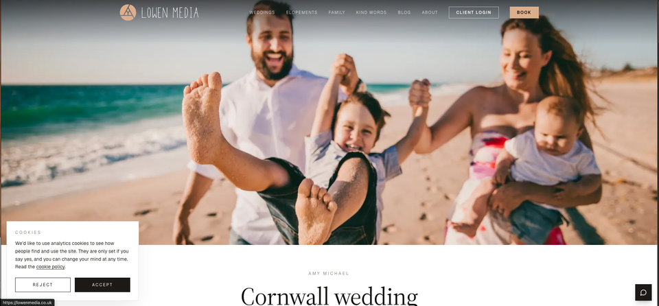 The Lowen Media homepage, with a family swinging their son between them on a sunny beach and the cookie consent banner in the